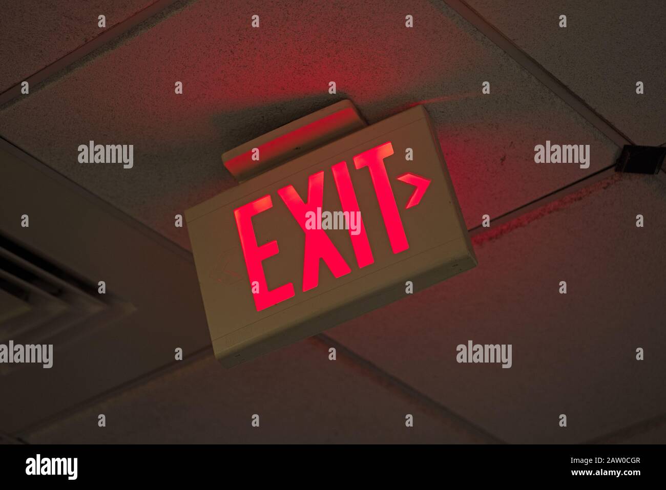 red lighted exit sign on drop ceiling with arrow Stock Photo Alamy