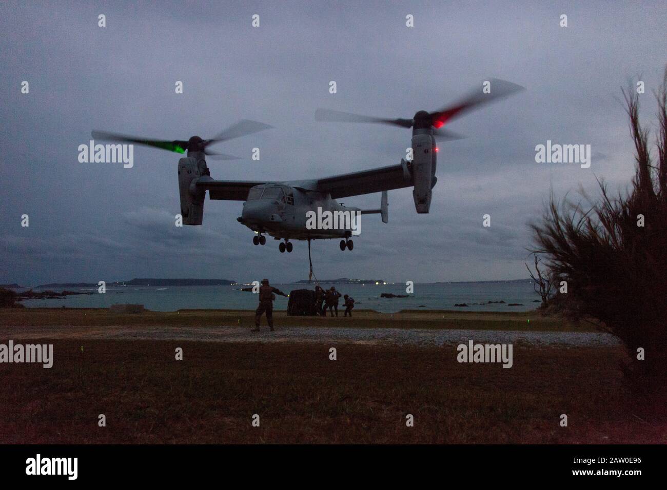 An MV-22B Osprey tiltrotor aircraft with Marine Medium Tiltrotor Squadron 265 (Reinforced) prepares to drop an external load during helicopter support team (HST) training at Kin Blue, Okinawa, Japan, Jan. 28, 2020. The purpose of an HST is to set up and secure a landing zone for aircraft as well as secure any external loads for pick up. The 31st Marine Expeditionary Unit, the Marine Corps’ only continuously forward-deployed MEU, provides a flexible and lethal force ready to perform a wide range of military operations as the premier crisis response force in the Indo-Pacific region. Stock Photo