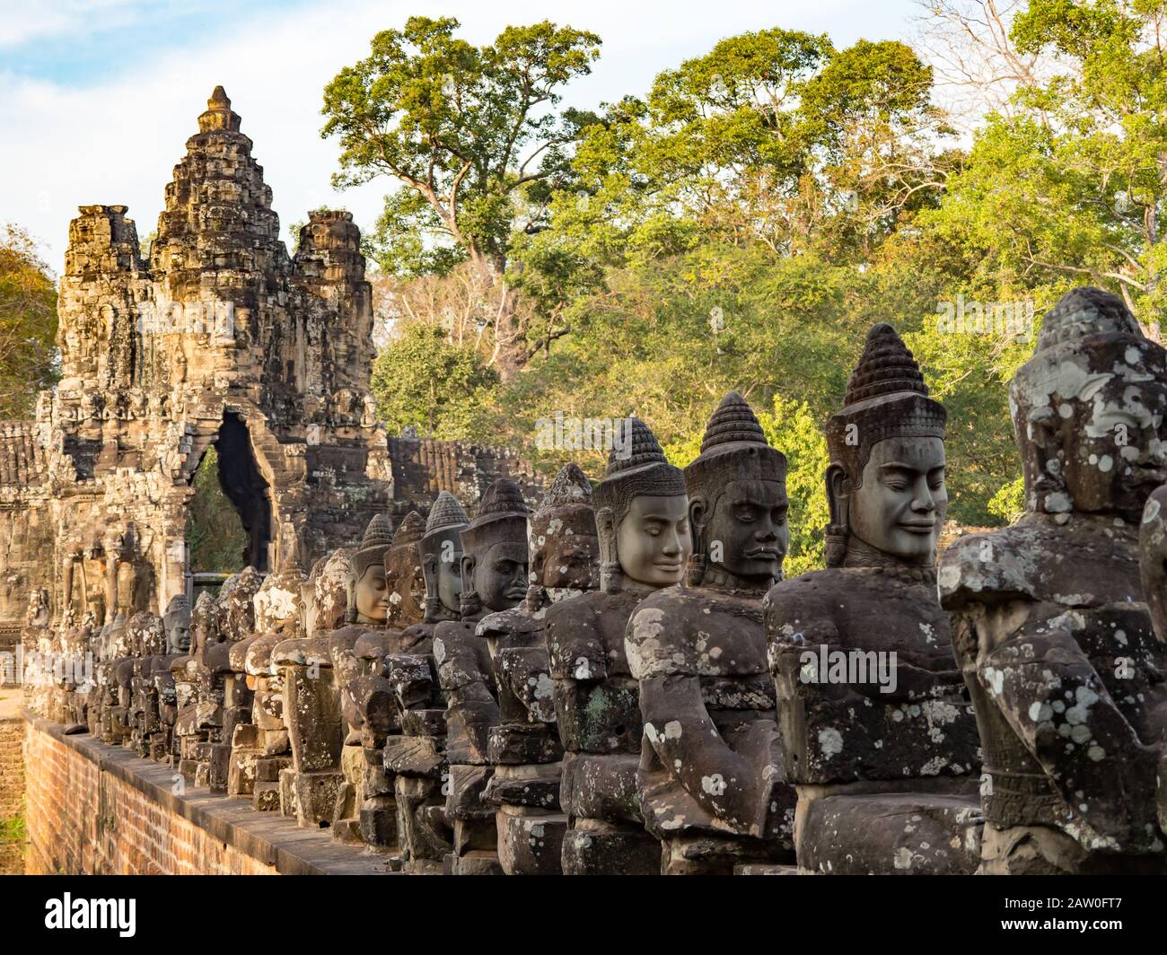 The bridge with statues at the entrance gate to Angkor Thom in Cambodia ...