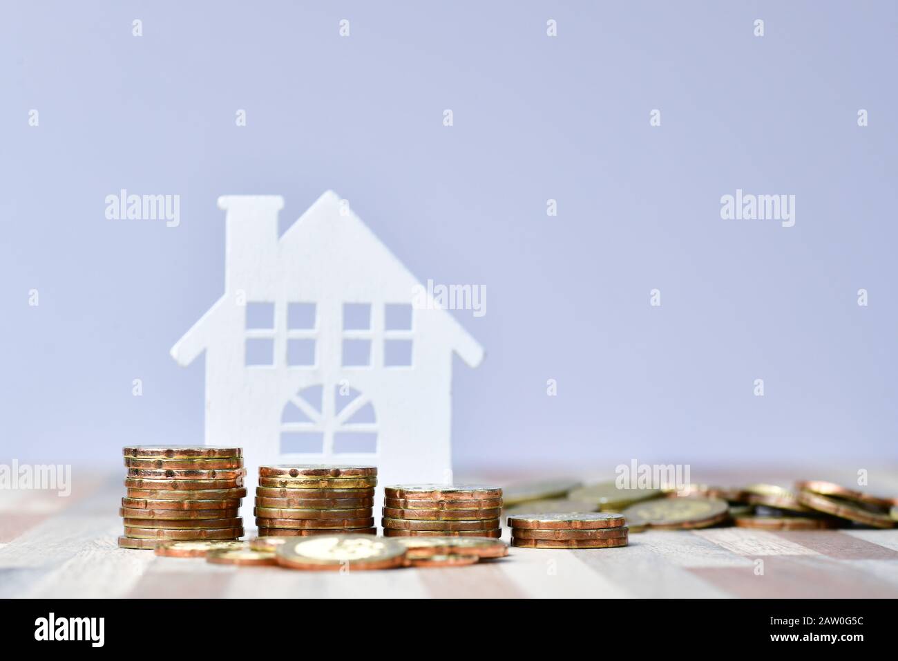 Close up of Wooden home and stack money coins of property investment concept Stock Photo