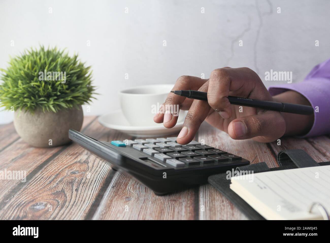 Closeup of man hand using calculator on table  Stock Photo