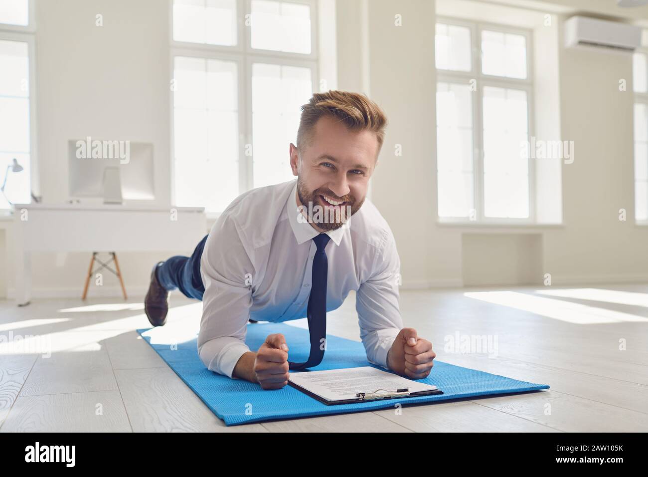 Businessman Doing Abs Strap Exercises While Lying In The Office