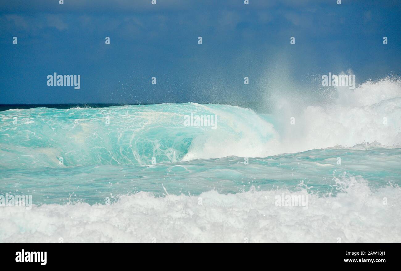 Surfers riding world-renowned crashing waves in Banzai Pipeline on North Shore, Oahu island, Haleiwa, Hawaii, USA Stock Photo