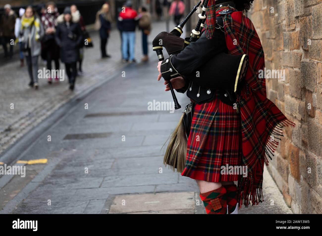 Scottish piper playing the bagpipes in traditional costume in Edinburgh