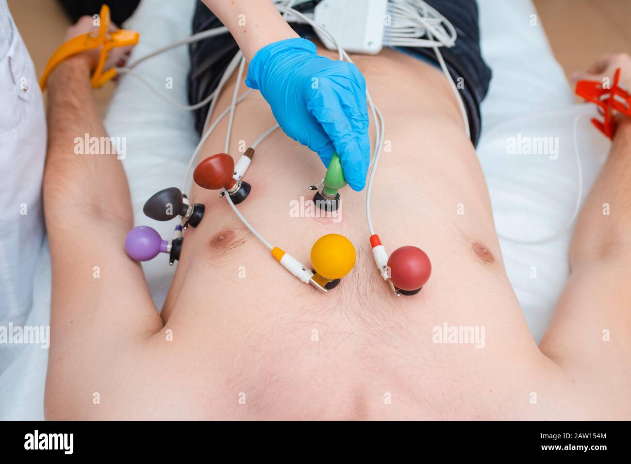 Cardiogram of the heart. The doctor attaches electrodes of an electrocardiograph to the patient’s chest. Cardiology Stock Photo