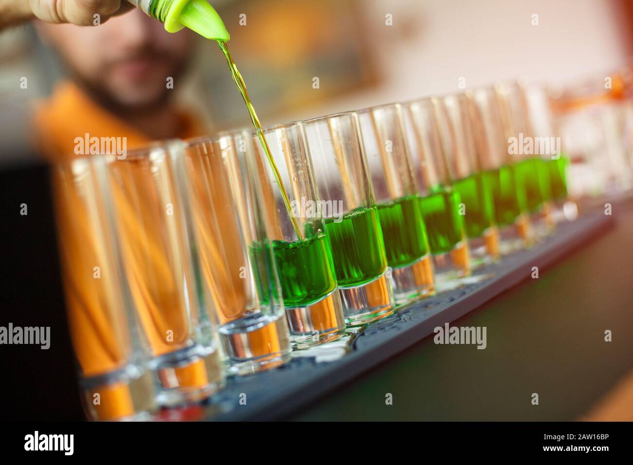 Bartender pouring absinthe in a glass. Concept of elite alcohol. Stock Photo