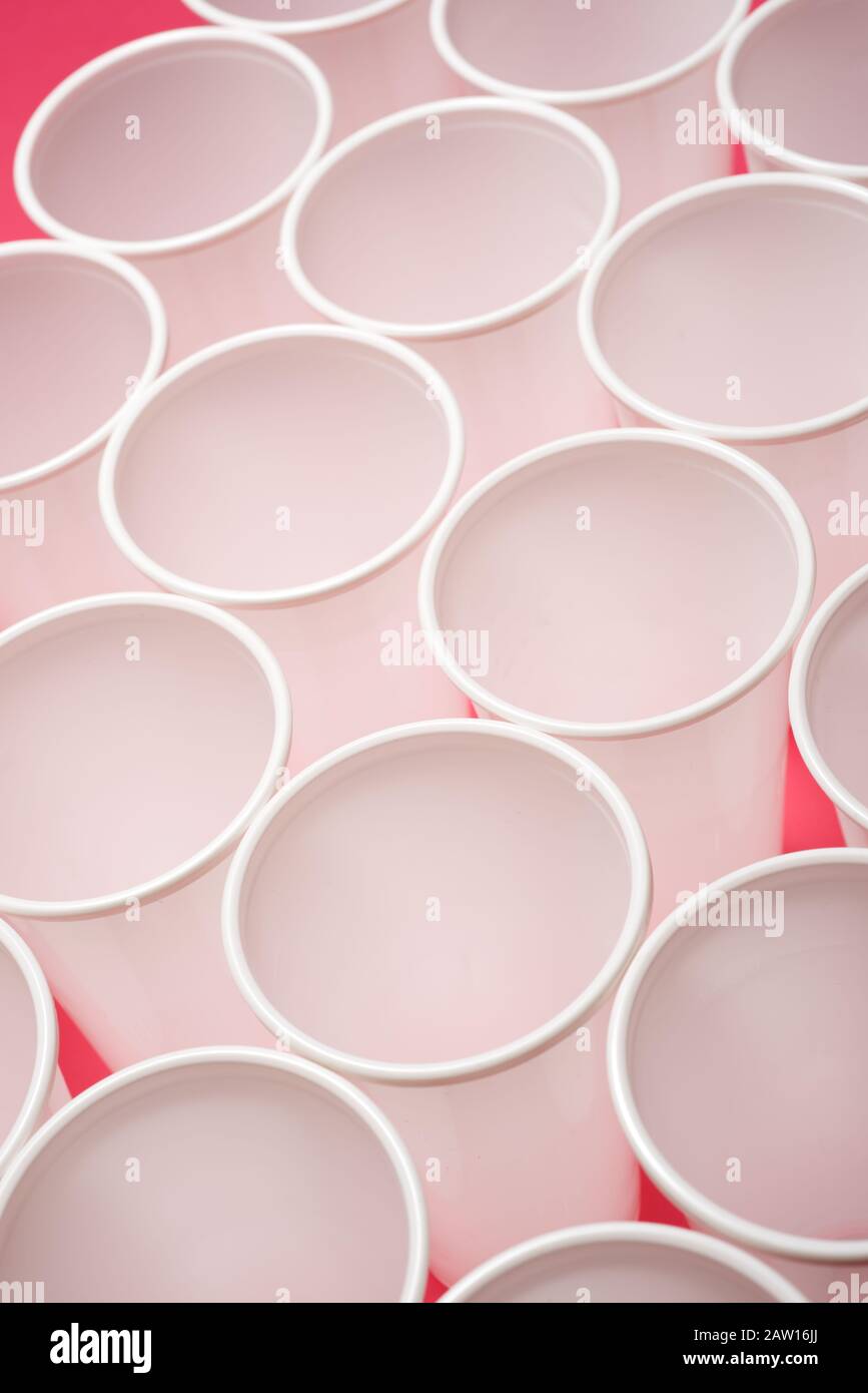 Large group of disposable plastic cups on a pink table Stock Photo Alamy
