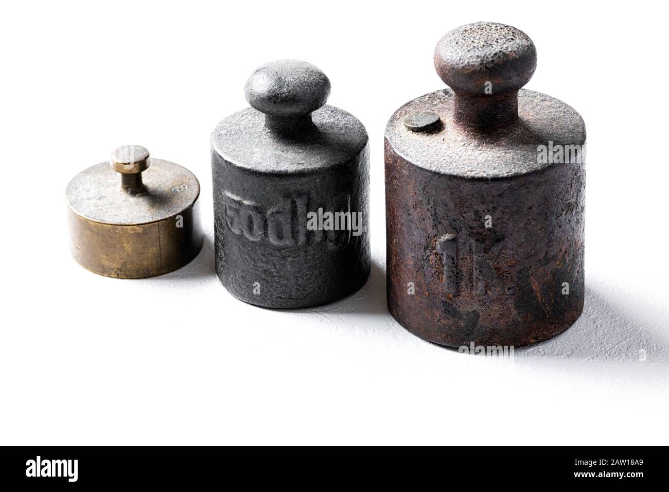 Old rustic metal weights on white background. Stock Photo