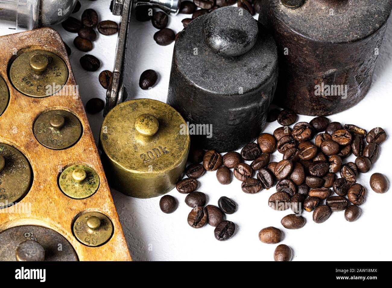 Old rustic metal weights with coffee beans on white background. Stock Photo
