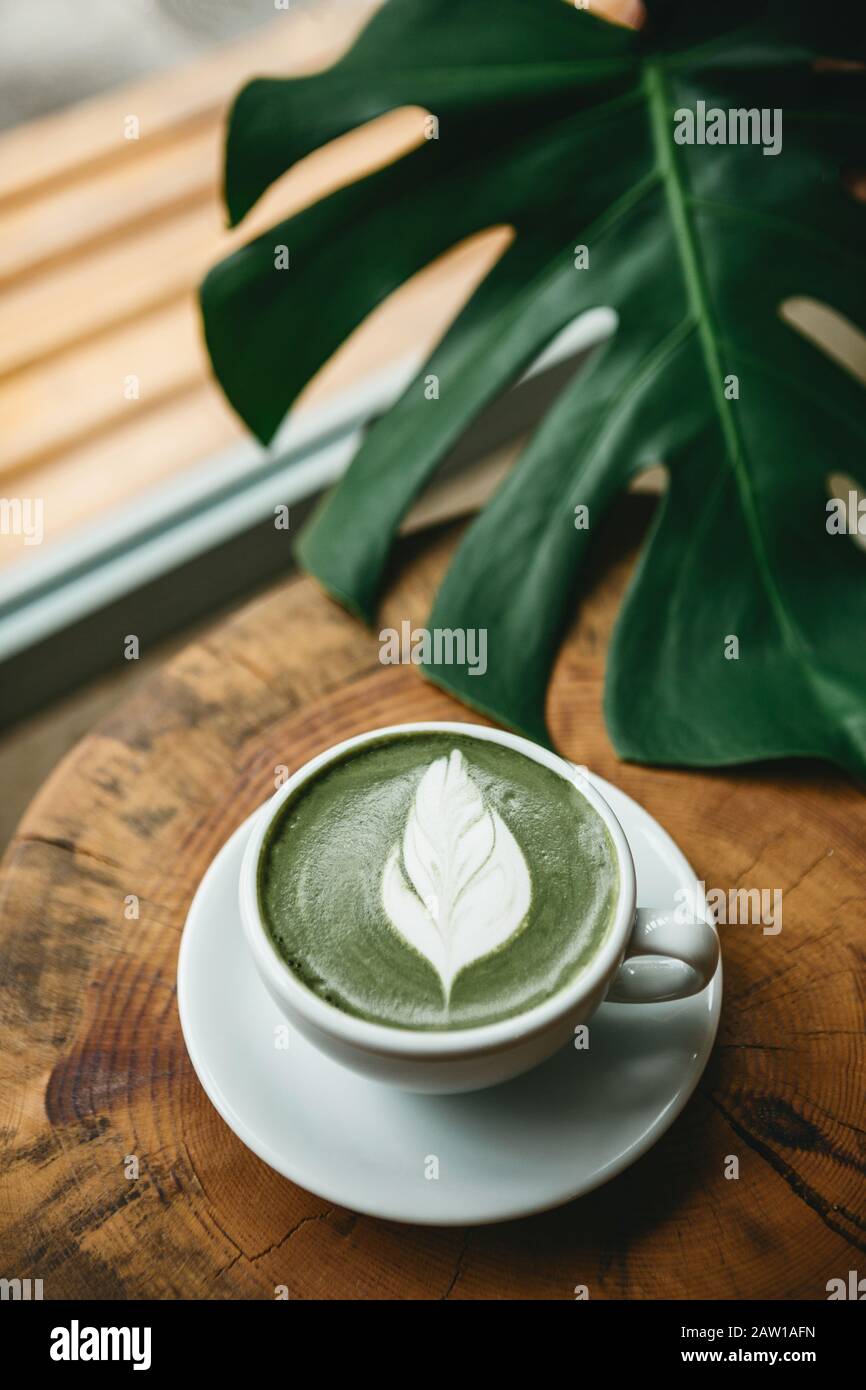 Fresh aromatic green matcha latte tea on a wooden table. Natural antioxidant and dietary product. Stock Photo