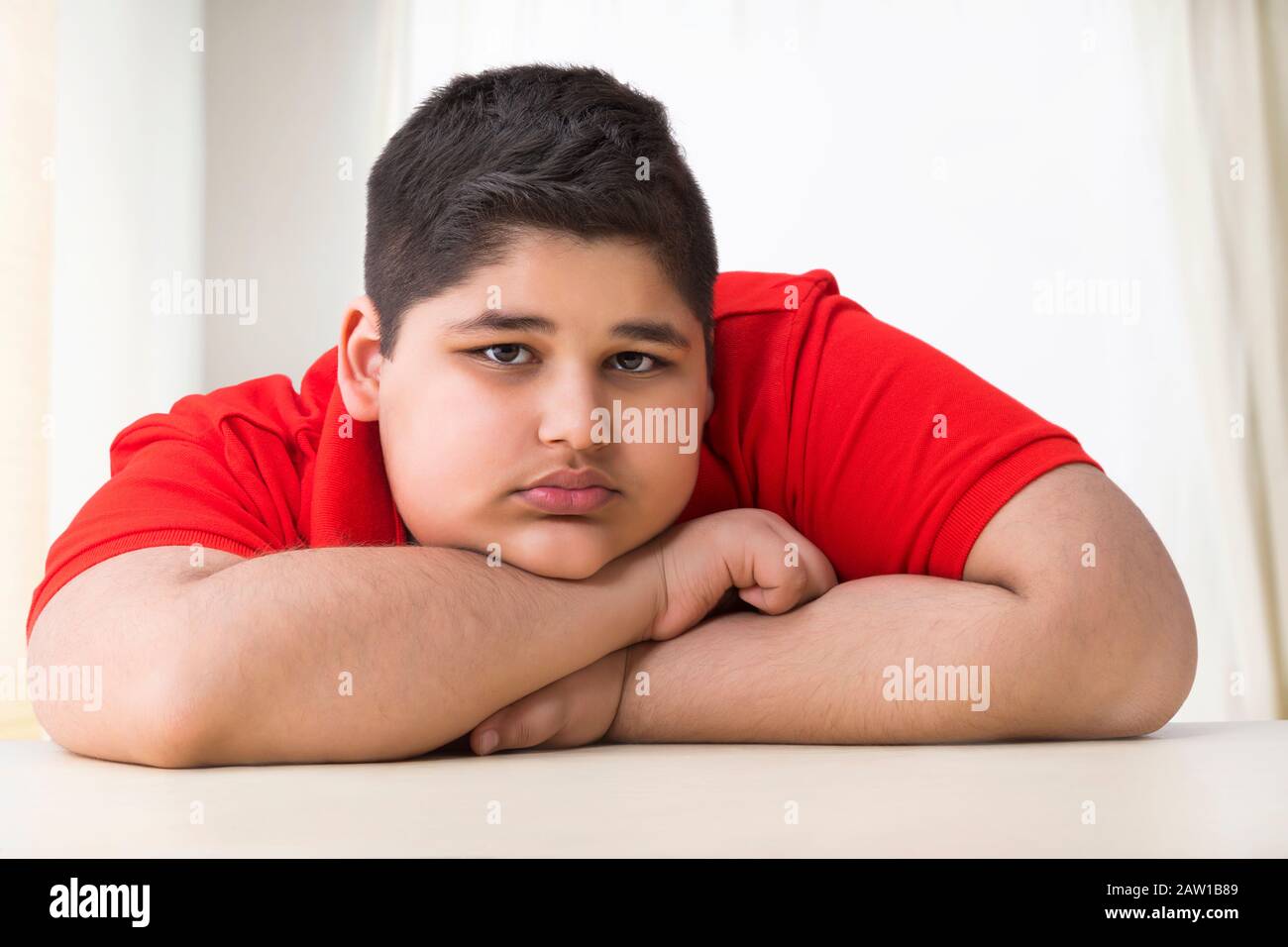 Portrait of a chubby boy lying on the table. (Obesity) Stock Photo