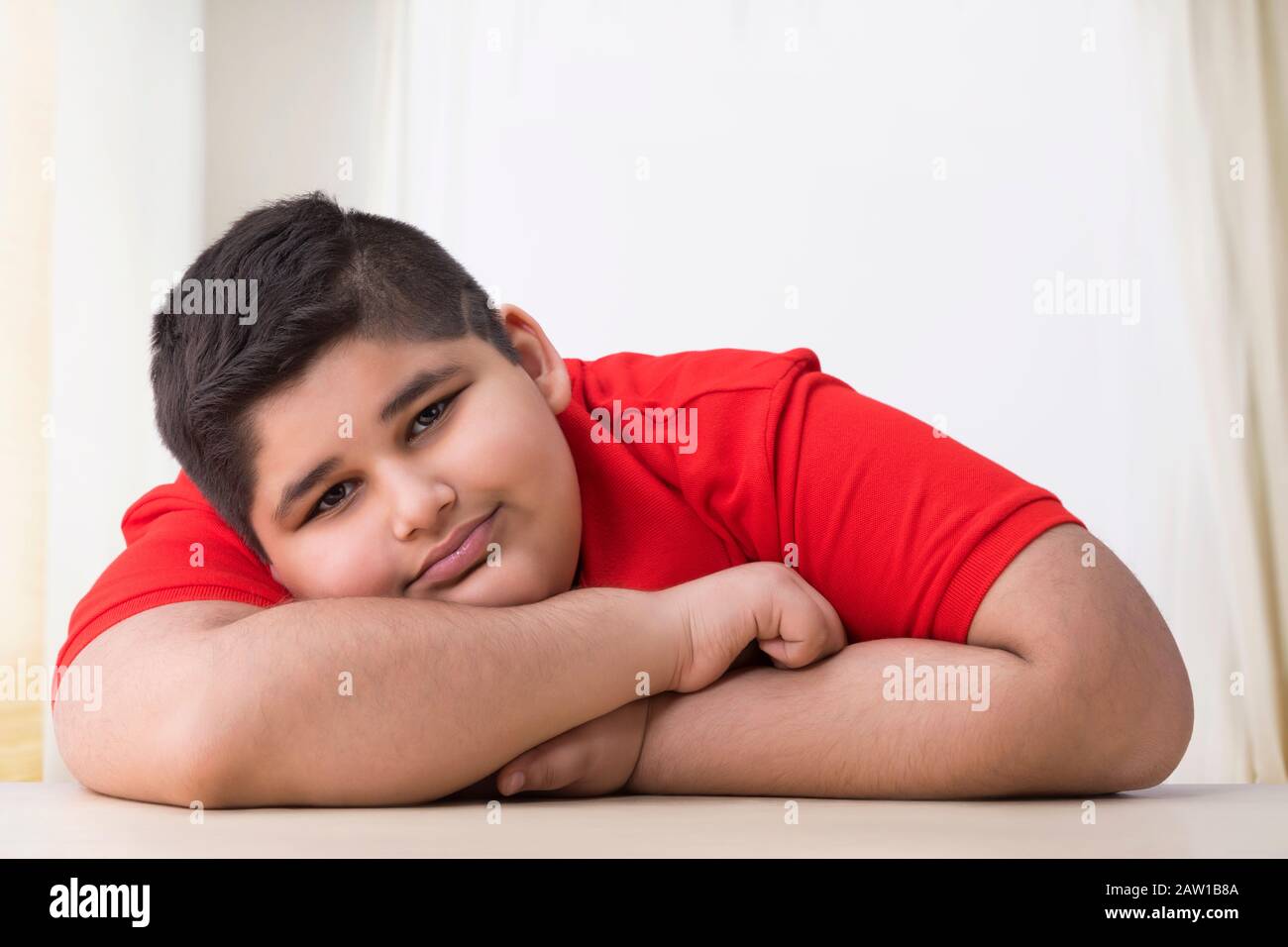 Portrait of a chubby boy lying on the table. (Obesity) Stock Photo