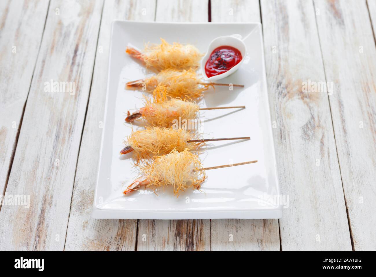 Crispy Shrimp wrapped in dough Kataifi called also Kanafeh, Kadaif. Served  with sauce on old wooden white background Stock Photo - Alamy