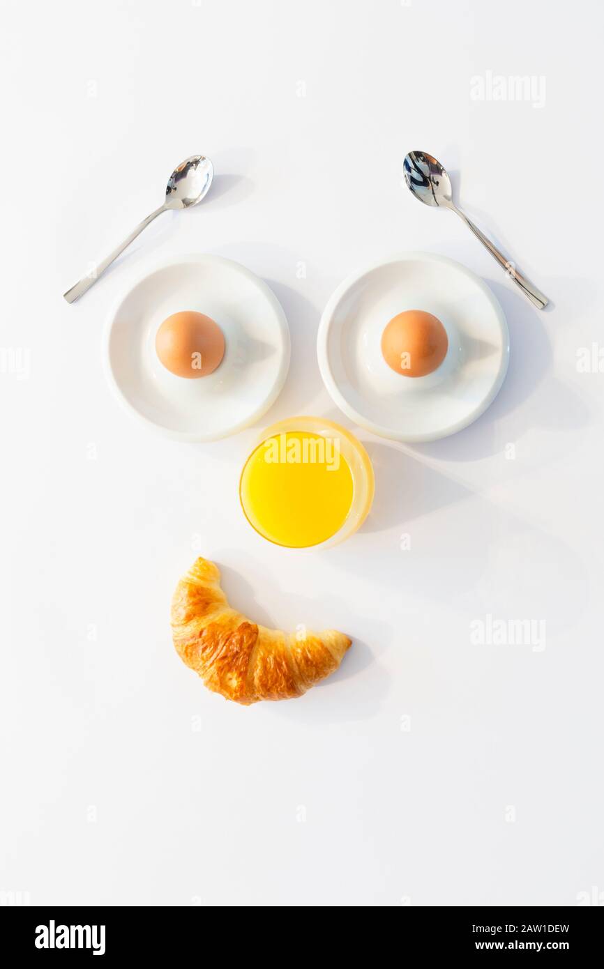 Fun breakfast concept with abstract smiling happy human face made of breakfast items on white background Stock Photo