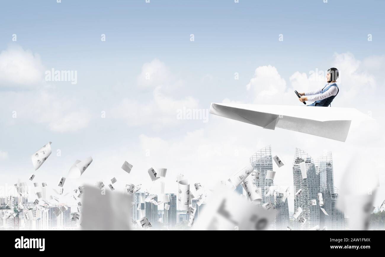 Aviator driving paper plane above business center Stock Photo - Alamy