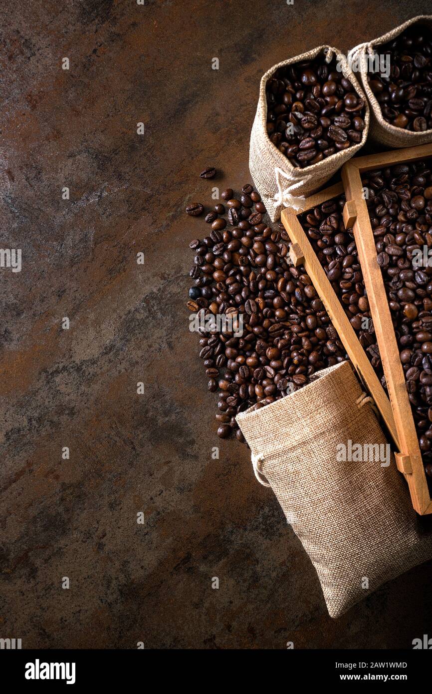Jute bags and wooden containers filled with cofee beans on the rust ...