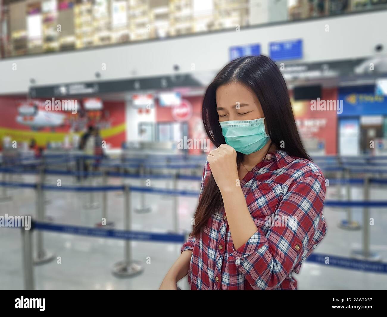 Asian tourist feeling sick, coughing ,wearing mask to prevent during travel time at the airport terminal for protect from the new Coronavirus 2019 inf Stock Photo
