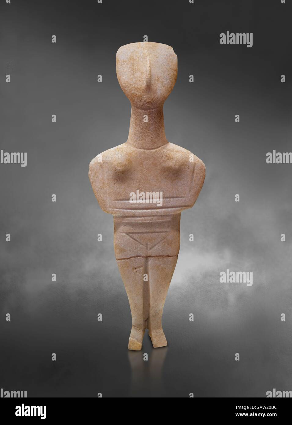 Cyclades spedos type stone statue figurine with folded arms, Archanes Phourni, 2300-1700 BC. Heraklion Archaeological Museum, grey background.  These Stock Photo