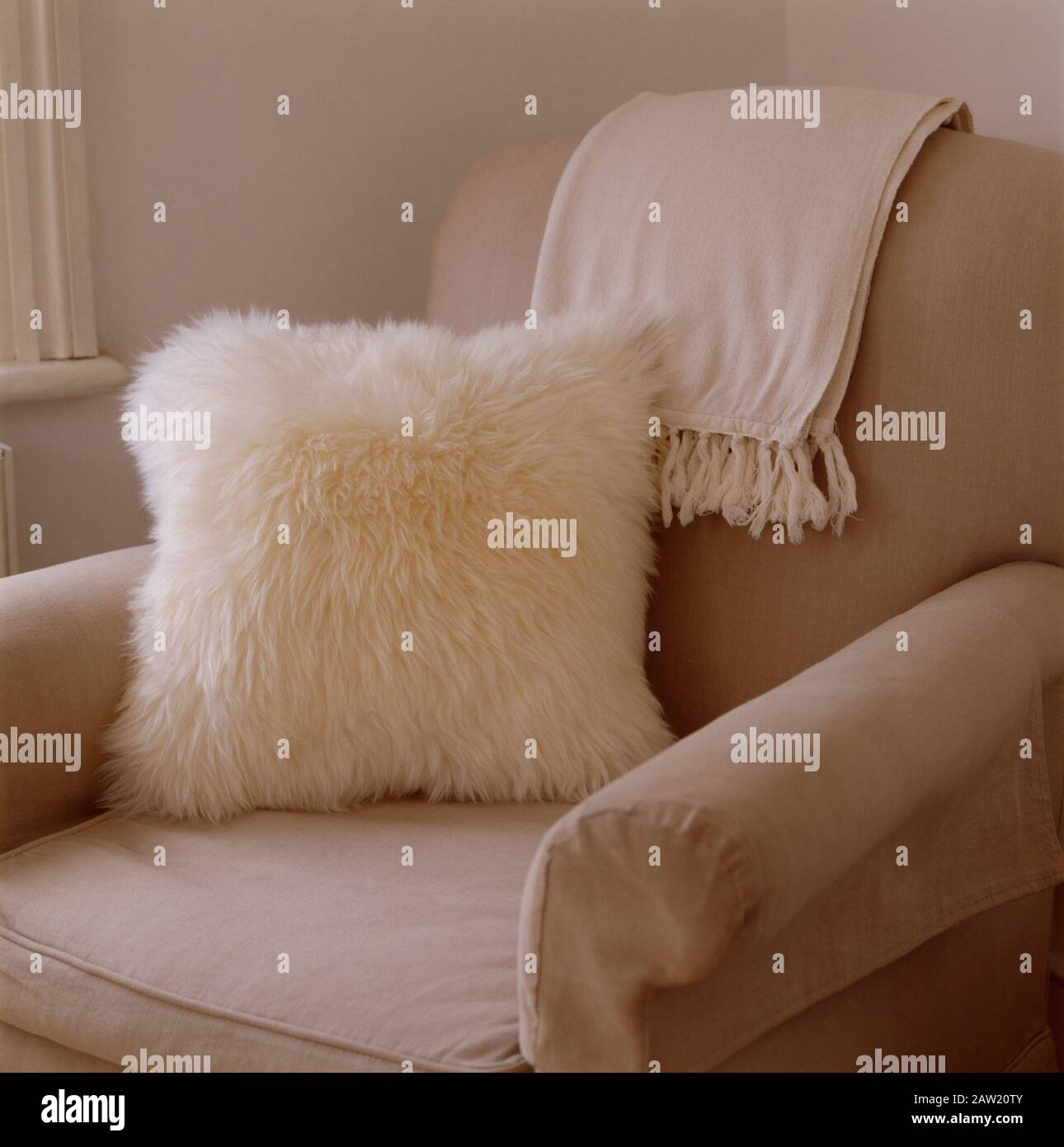 White fluffy cushion on beige armchair Stock Photo Alamy