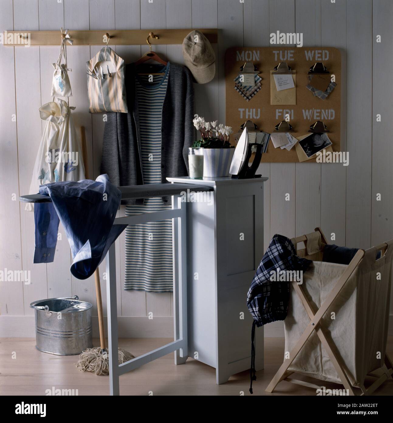 Iron on a cupboard with a pullout ironing board in an economy utility