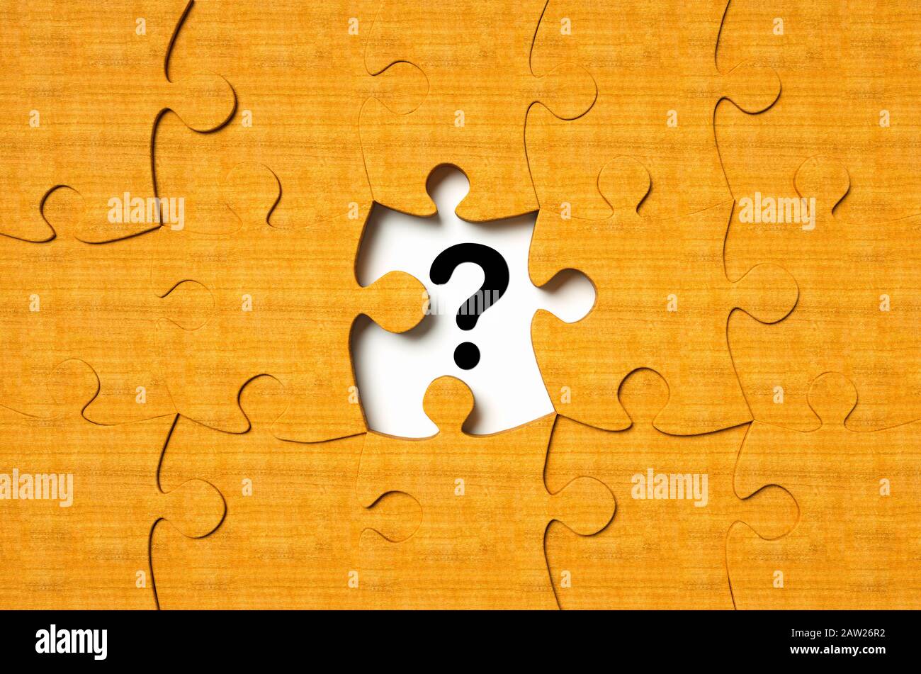 Blank wooden jigsaw puzzle with one piece missing and question mark symbol Stock Photo