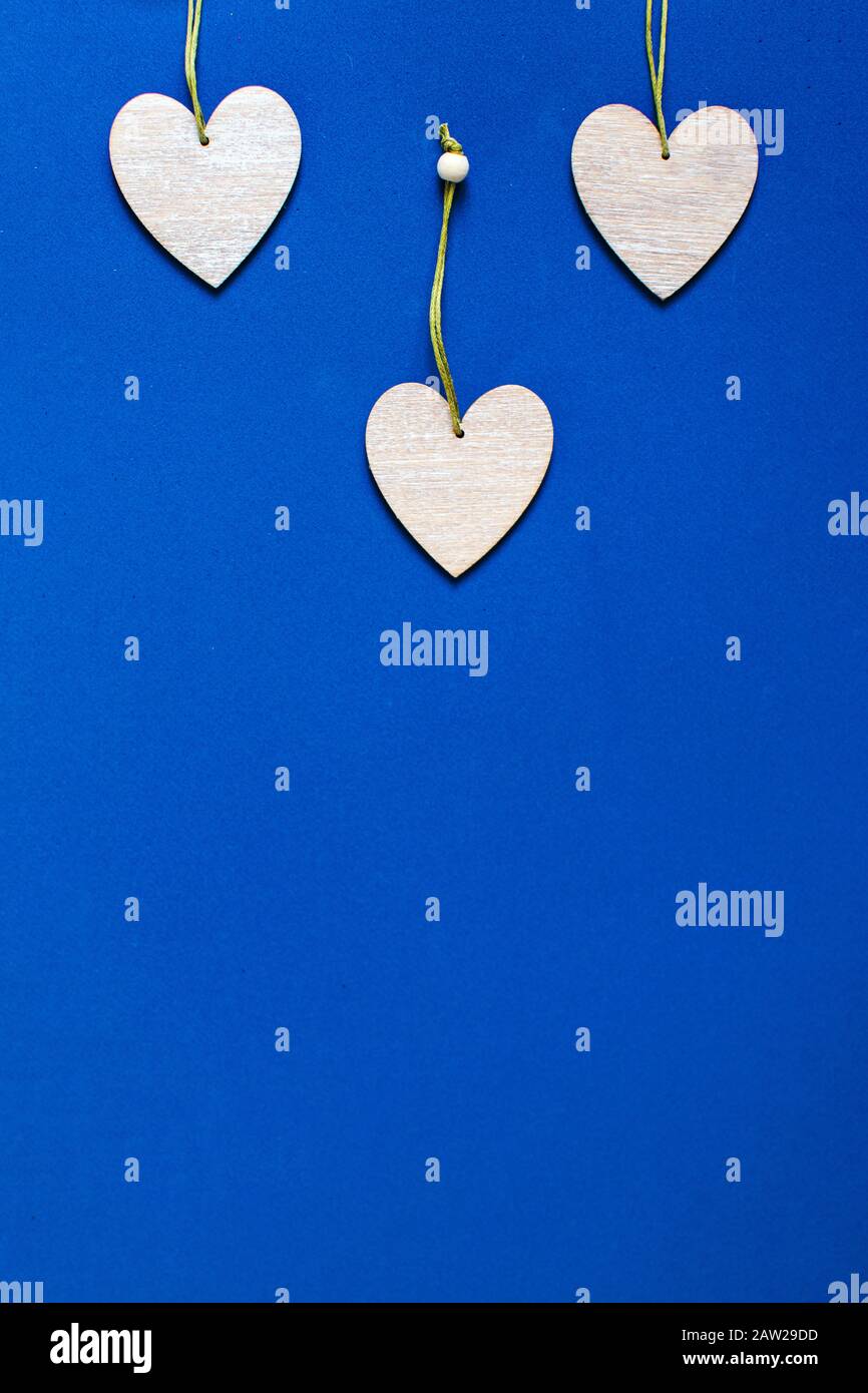 Wooden hearts on classic blue background. Valentine's Day Greeting Card ...