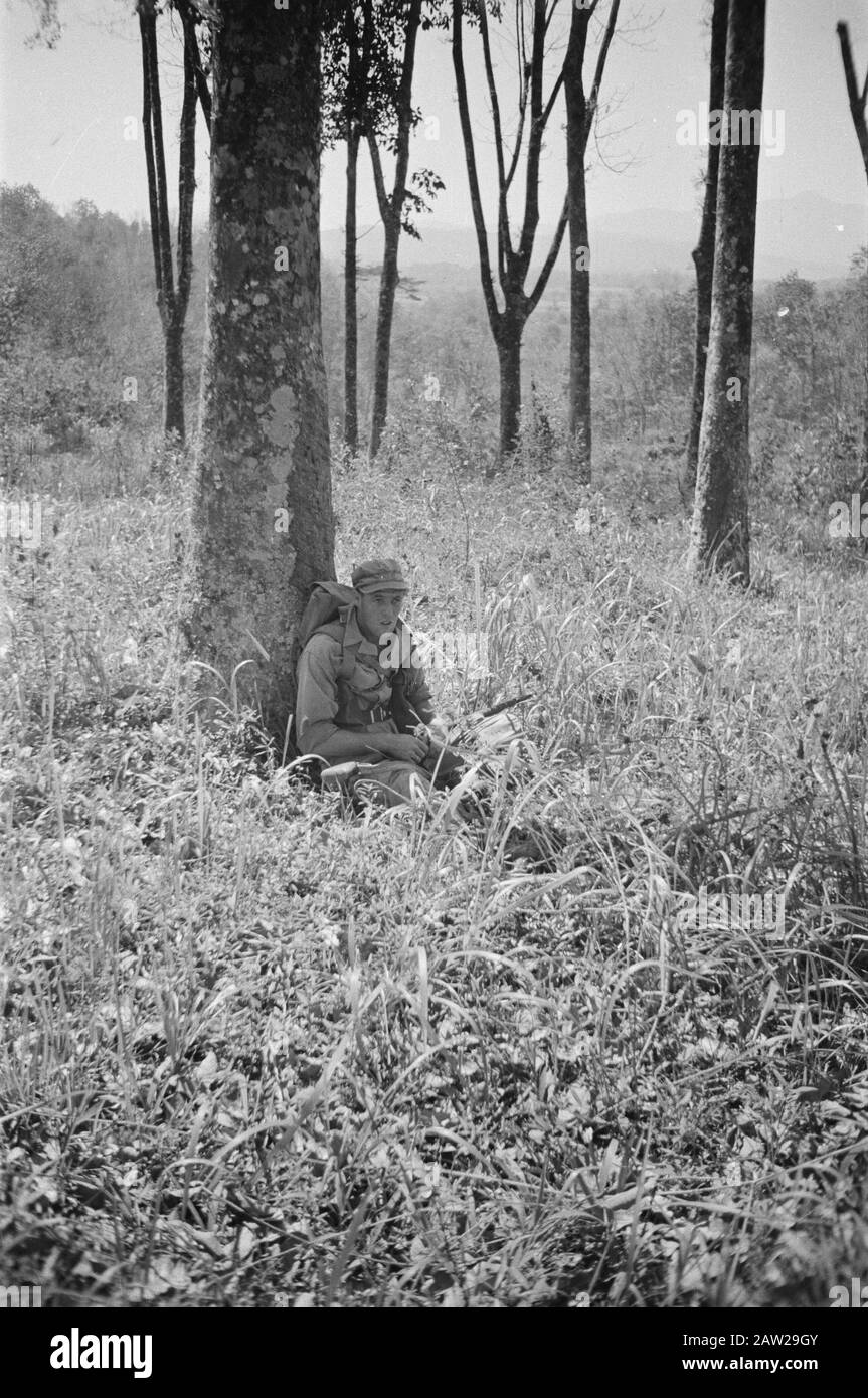 1st Infantry Brigade  Patrol. Soldier resting against a tree Date: July 1947 Location: Bogor, Buitenzorg, Indonesia, Dutch East Indies Stock Photo