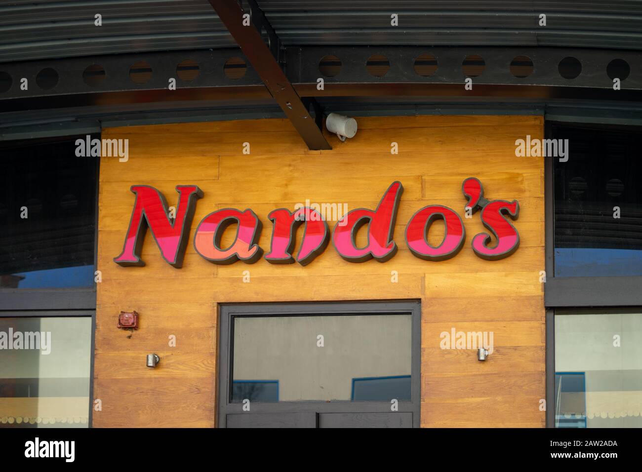 The exterior of a Nando's fast food restaurant with a sign above the entrance Stock Photo