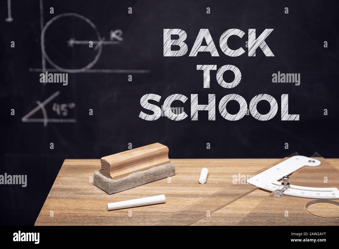 Back to school background. School table with chalk and eraser and a blackboard with geometric drawings in the chalkboard Stock Photo