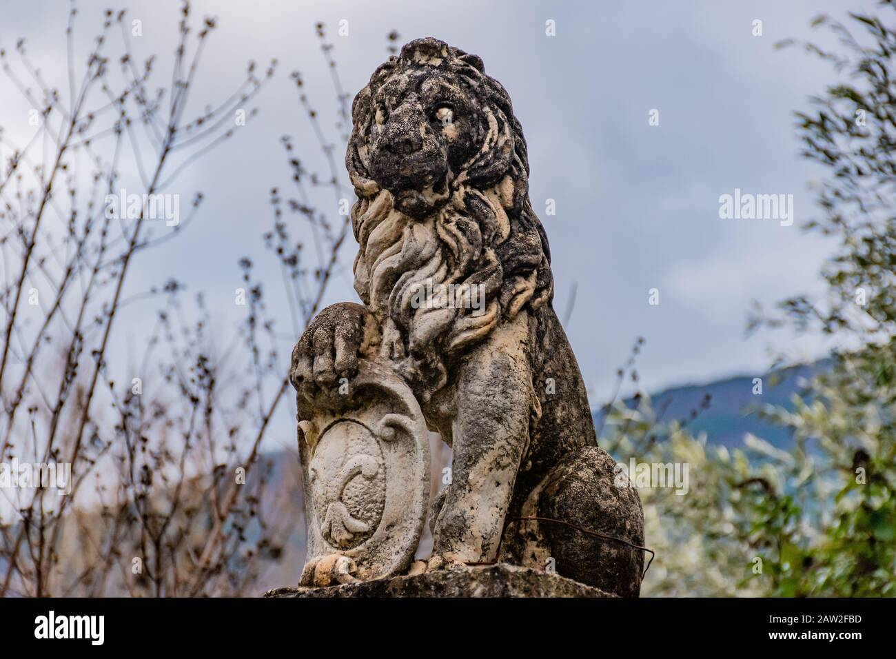 Puget-Theniers, France - January 23, 2020: A statue of a lion holding the 'fleur-de-lis' emblem ('fleur-de-lys'; Iris versicolor) Stock Photo