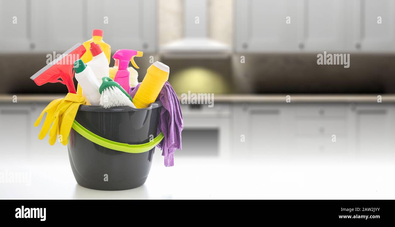 Cleaning products against blur kitchen interior background. Chemical detergents in a bucket, home kitchen household concept, copy space Stock Photo