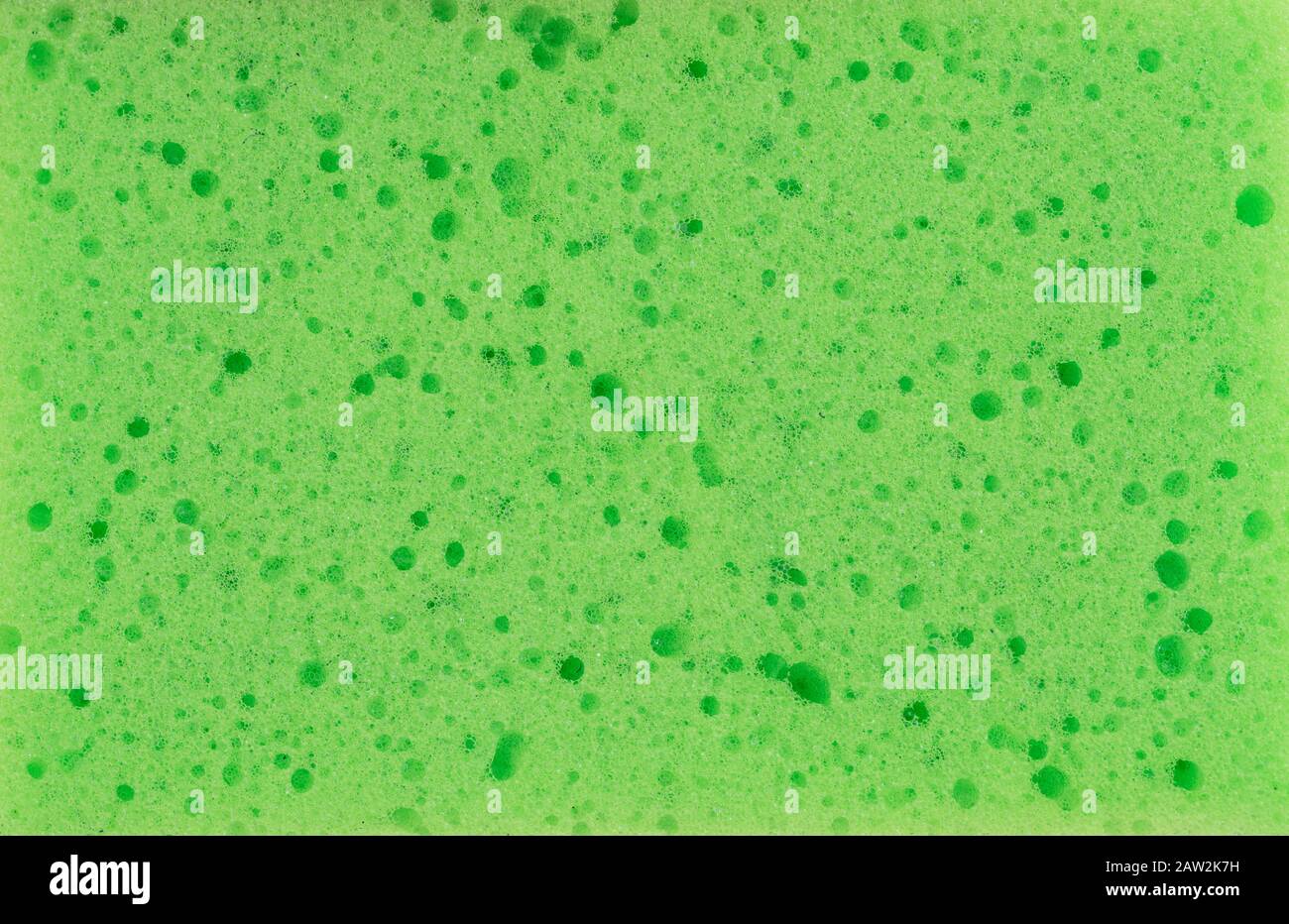 Sponge texture background. Green color cleaning sponge material detail close up view. Dish washing or beauty care. Macro Stock Photo