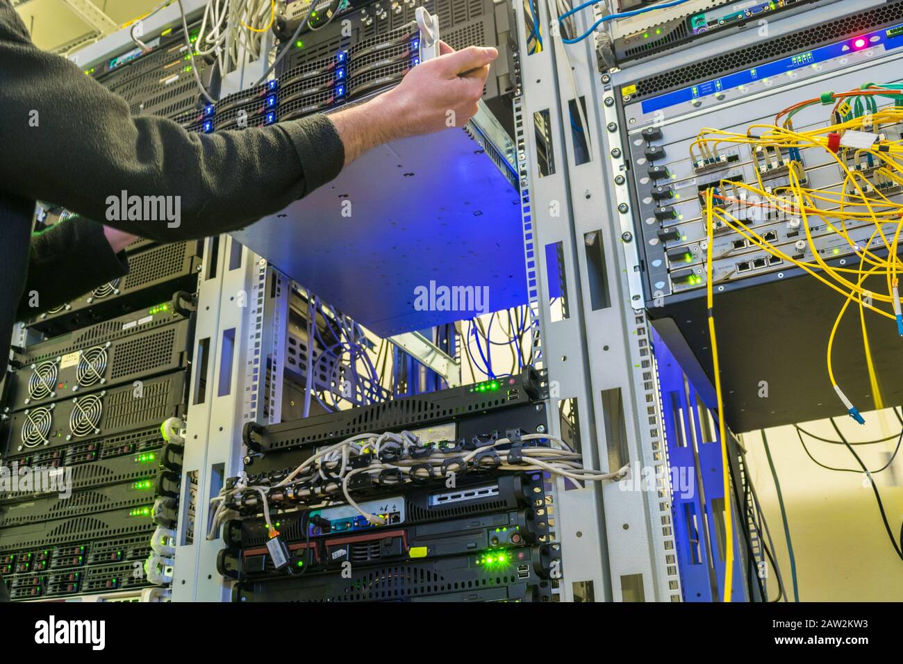 Server maintenance in the data center. Service of computer equipment in the  information center rack. The technical spicheist installs a new router. Th  Stock Photo - Alamy