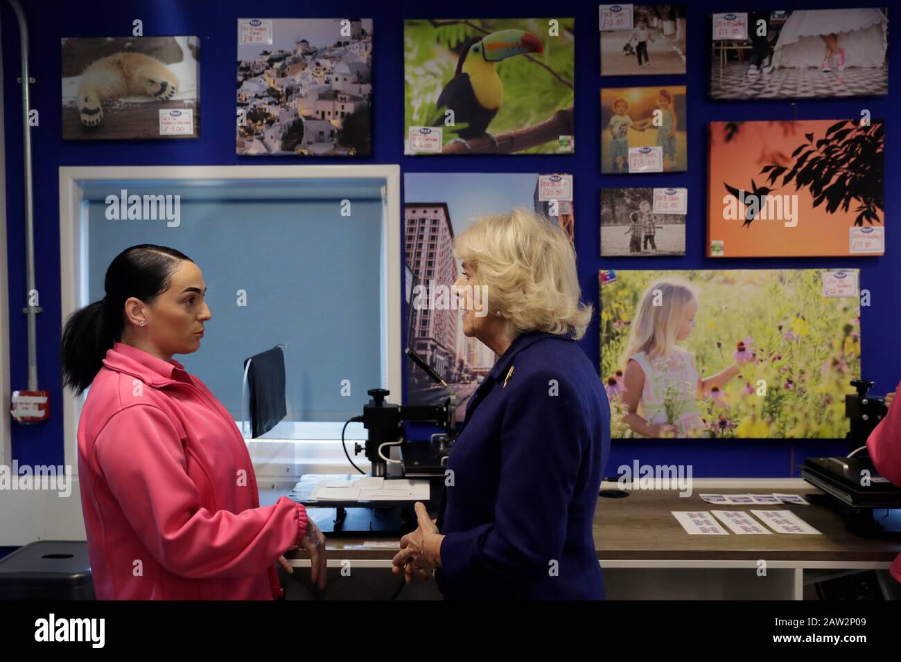 The Duchess of Cornwall (left) speaks with Marsida, a prisoner, being trained in the Max Spielmann Academy, an onsite shop where inmates are trained in up-to-date photographic industry techniques, during a visit to Her Majesty's Prison Downview in Sutton, Surrey. Stock Photo