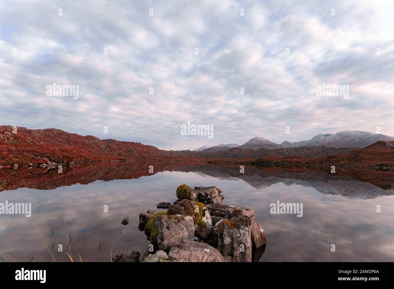 Calm Day on a Scottish Loch or Lake with reflections and Clouds Stock Photo