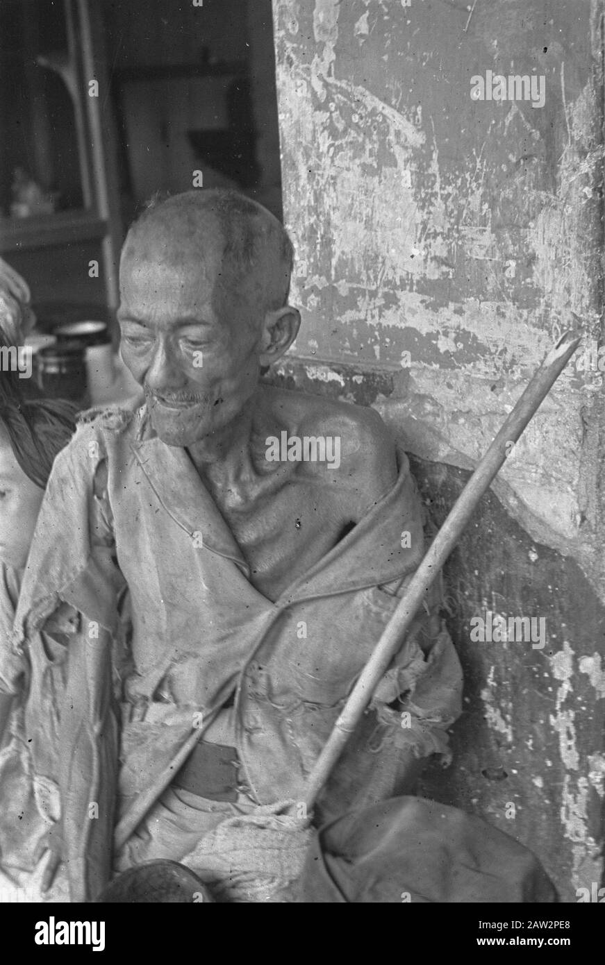 Photoreportage Palembang  Outpatient? Emaciated elderly man dressed in rags Date: 1947 Location: Indonesia Dutch East Indies Stock Photo