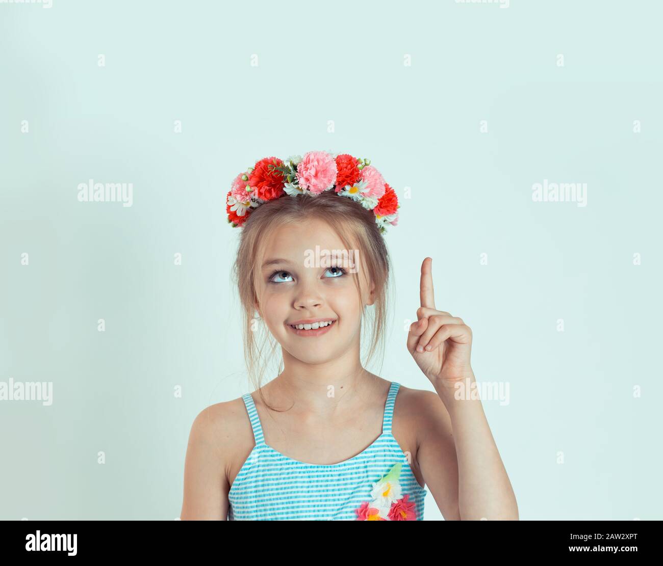 portrait-closeup-of-a-cute-kid-girl-pointing-index-finger-up-and