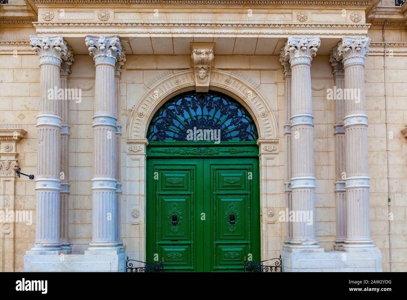 The facade of a historic building with big stone columns and