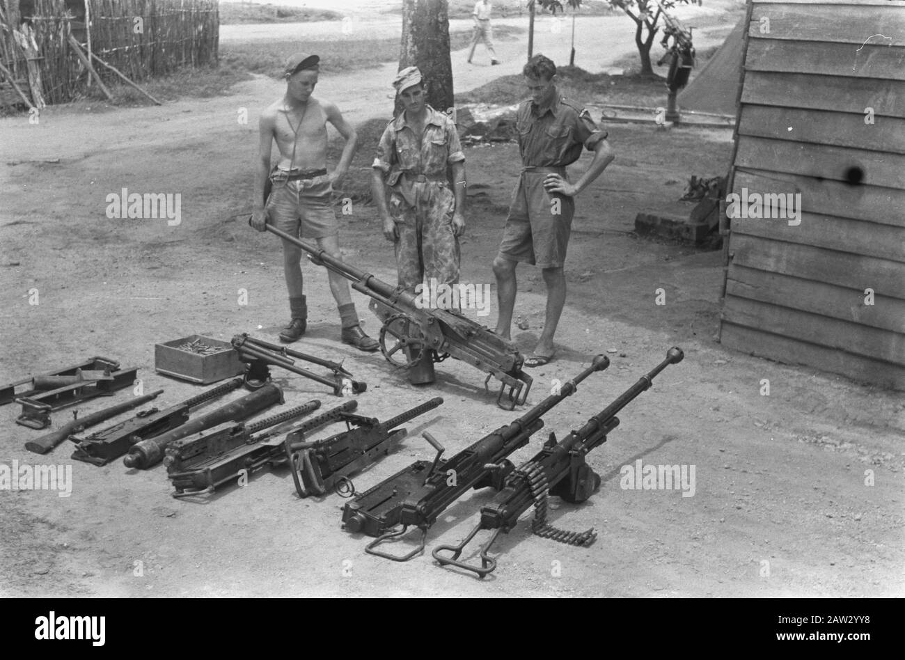 Booty Captured weapons Praboemoelih  Praboemoelih: Sergeant. G. H. Smeets of K.N.I.L. (Gadja Merah) and second husband of seven R.S. standing proudly looking at the weapons detected by them. Date: October 26, 1947 Location: Indonesia, Dutch East Indies, Prabumulih, Sumatra Stock Photo