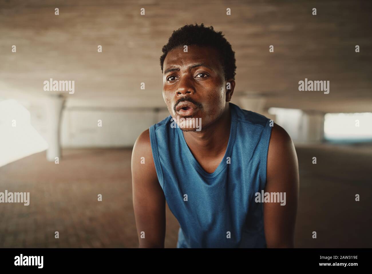 Portrait of a fit young male athlete feel fatigue taking a break after morning run Stock Photo