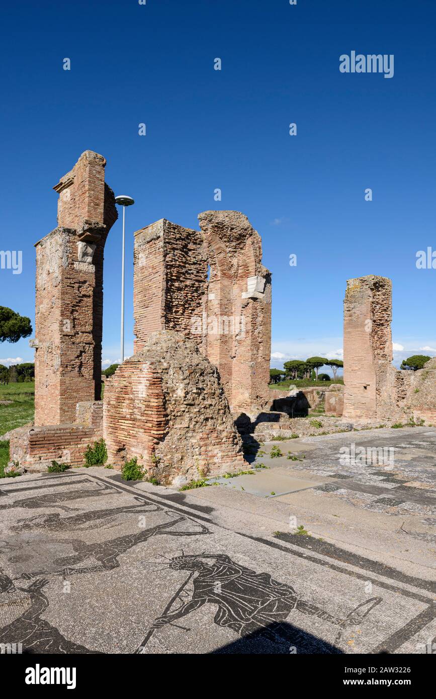 Rome. Italy. Ostia Antica. Terme di Porta Marina (Baths of the Porta Marina). Brick piers of the apse, in the foregound are floor mosaics depicting a Stock Photo