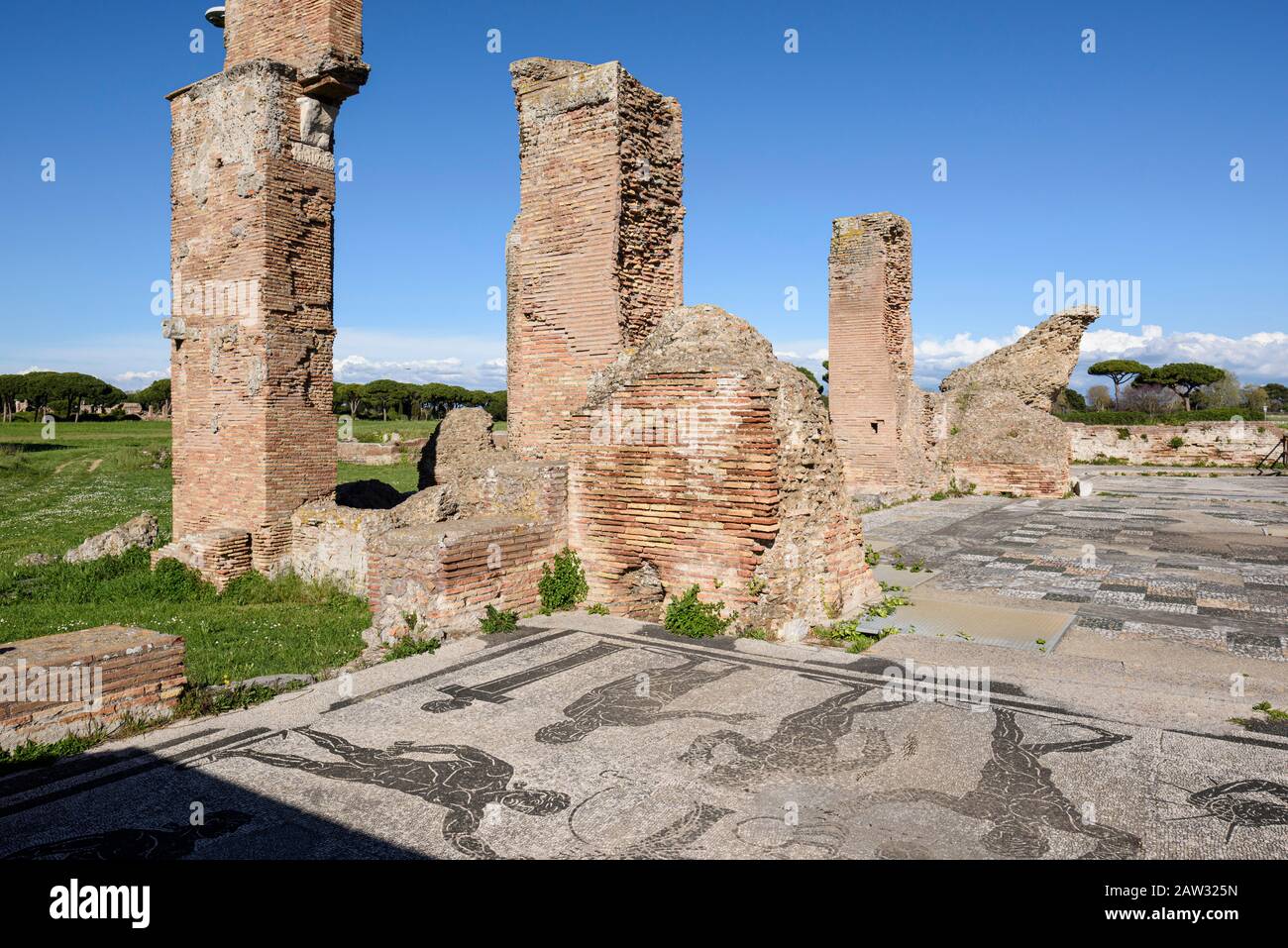 Rome. Italy. Ostia Antica. Terme di Porta Marina (Baths of the Porta Marina). Brick piers of the apse, in the foregound are floor mosaics depicting at Stock Photo