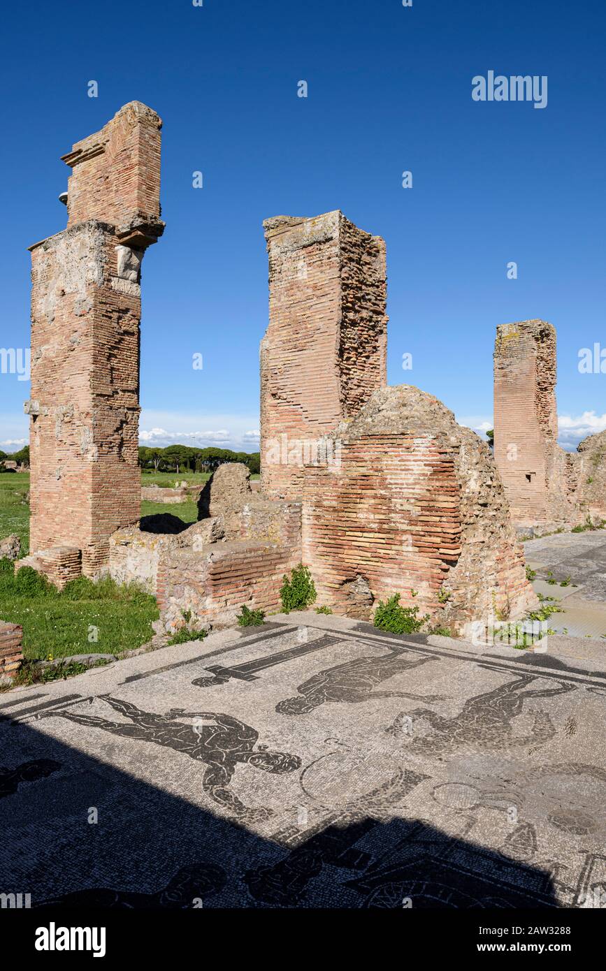 Rome. Italy. Ostia Antica. Terme di Porta Marina (Baths of the Porta Marina). Brick piers of the apse, in the foregound are floor mosaics depicting at Stock Photo