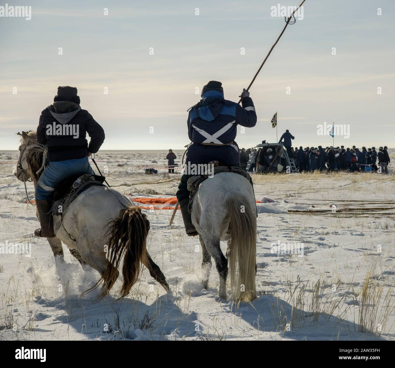 Two locals on horseback arrive at the Soyuz MS-13 spacecraft shortly after it landed in a remote area near the town of Zhezkazgan, Kazakhstan with Expedition 61 crew members Christina Koch of NASA, Alexander Skvortsov of the Russian space agency Roscosmos, and Luca Parmitano of ESA (European Space Agency) Thursday, Feb. 6, 2020. Koch returned to Earth after logging 328 days in space --- the longest spaceflight in history by a woman --- as a member of Expeditions 59-60-61 on the International Space Station. Skvortsov and Parmitano returned after 201 days in space where they served as Expedition Stock Photo