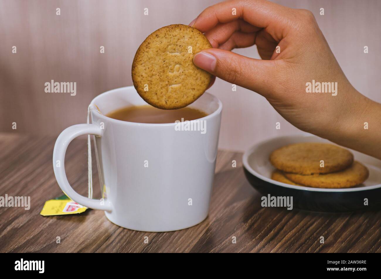 Milk tea and biscuits female hand Stock Photo Alamy