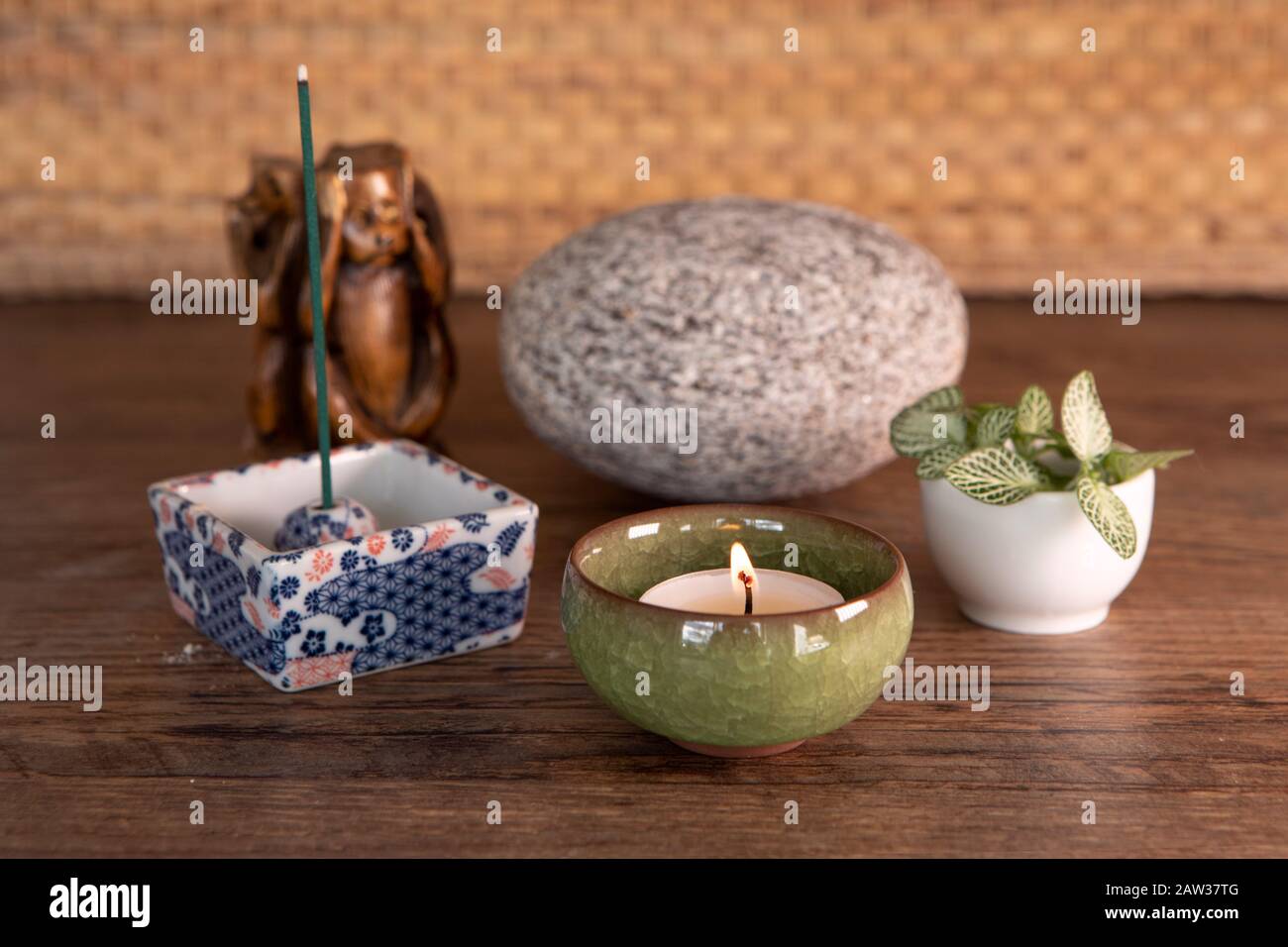 Burning incense, stone, fresh plant leaves, candlelight. Yoga, meditation equipment Stock Photo
