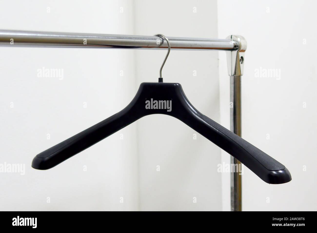 Empty plastic hangers hanging in a wardrobe for clothes Stock Photo