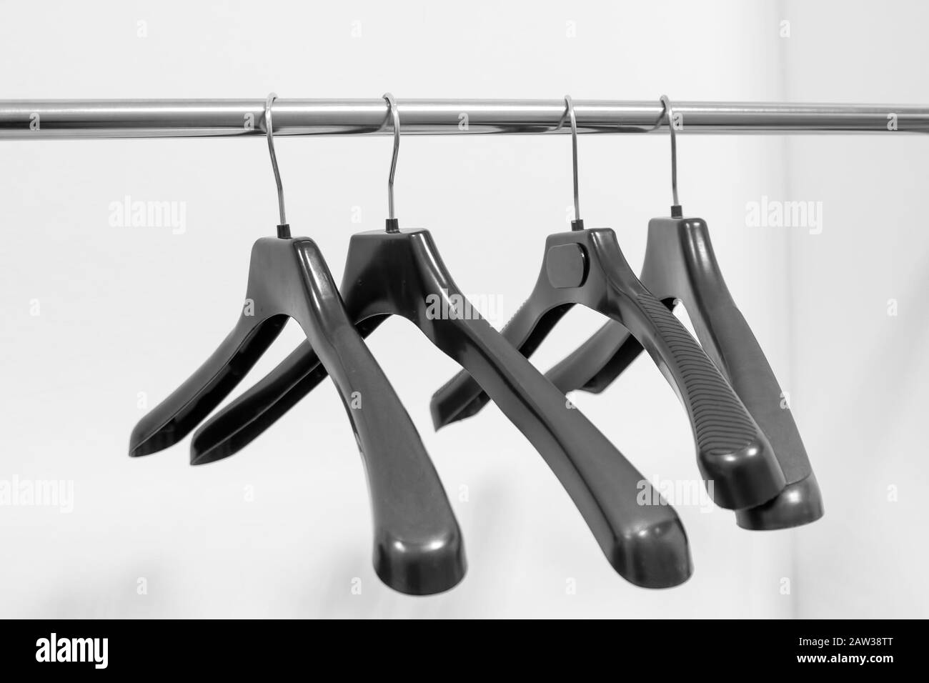 Empty plastic hangers hanging in a wardrobe for clothes Stock Photo
