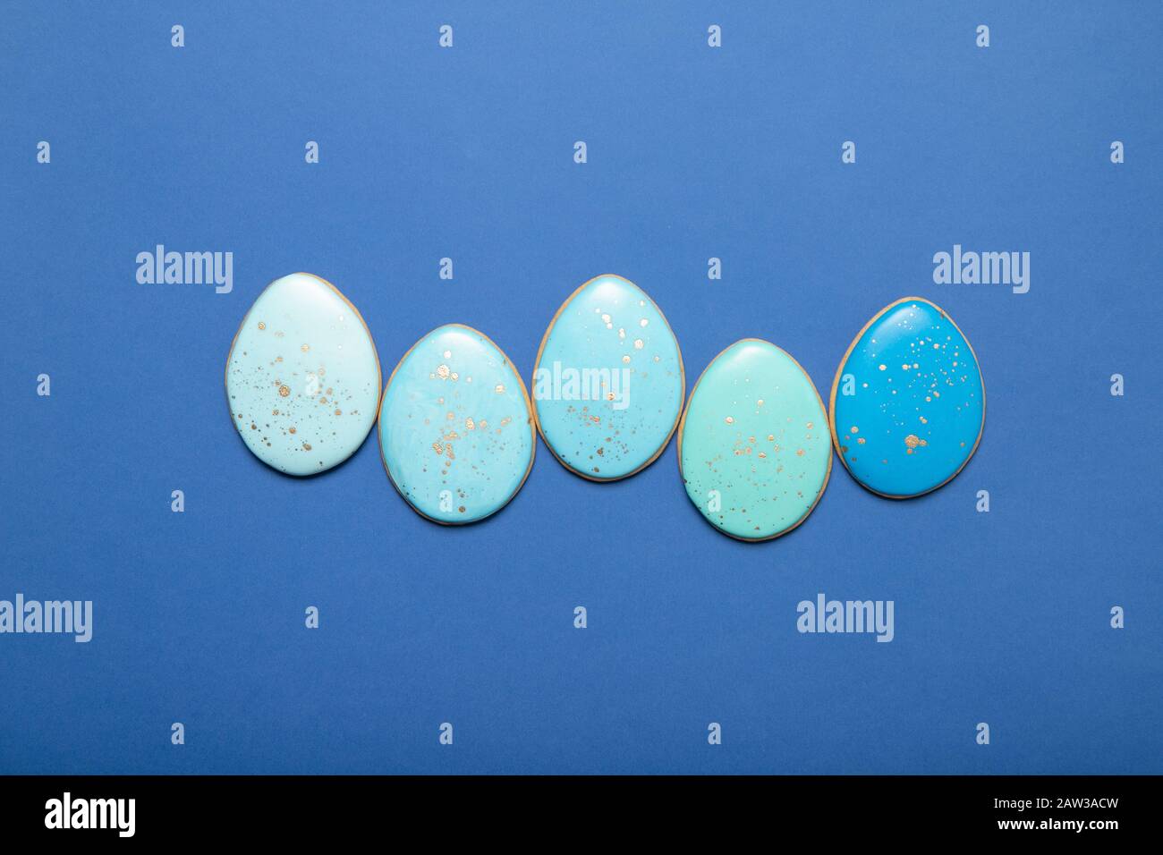 Easter cookies on a plate on a blue background. Place for text. Easter eggs. Stock Photo