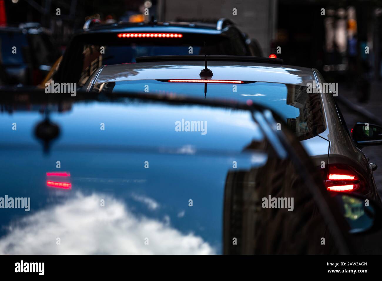 A closeup of cars with the brake lights on in evening traffic in